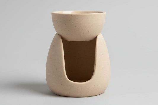 Brûle-parfum en terre cuite beige pour fondants parfumés, photographié de face sur fond clair.
